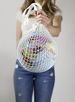 Girl holds an earth globe in a string bag. plastic free concept, eco friendly, zero waste lifestyle, conscious resource