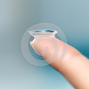 Girl holds finger on a contact lens, closeup