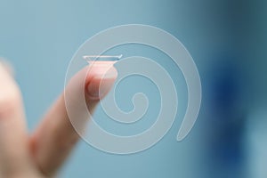 Girl holds finger on a contact lens, closeup