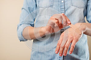 The girl holds and glues the patch on the hand, on the wound, treatment, throwing while smoking