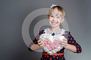 The girl holds with hands heart and laughs.