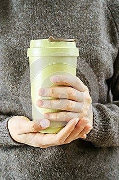Girl holds in her hands bamboo cup. Zero waste concept