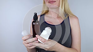 Girl holds in her hands three eco-friendly antiperspirants with natural ingredients.