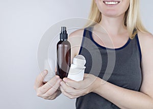 Girl holds in her hands three eco-friendly antiperspirants with natural ingredients. Refusal of antiperspirants containing toxic