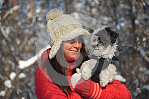 Girl holds her little dressed dog