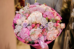 Girl holds a huge bouquet of different pink and purple flowers