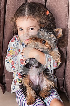 Girl holds puppy in hands