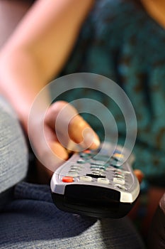 Girl holds remote control for TV