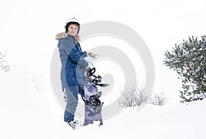 The girl holds a snowboard in her hands, she is dressed in a mountain jacket and a helmet