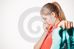 Girl holds stinky sneakers and closes her nose