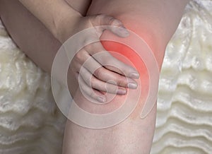 The girl holds on to the knee, the red knee, arthrosis of the knee, close-up arthrosis photo