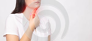 The girl holds on to the sore red throat on a white background. Concept of sore throat, laryngitis and sore throat in coronavirus photo