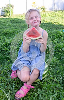 The girl holds watermelon slices in her hands.