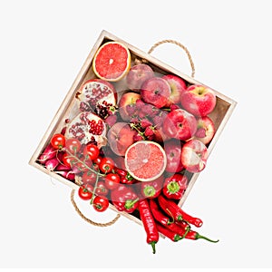 Girl holds wooden tray with fresh red vegetables and fruits on white background. Healthy eating vegetarian concept.