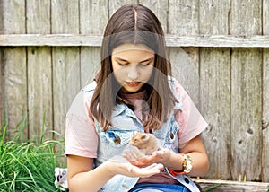 Girl holdÑˆÑ‚Ð¿ a hamster in hands