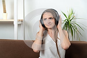 Girl at home with headphones listening to music, audiobook podcasts