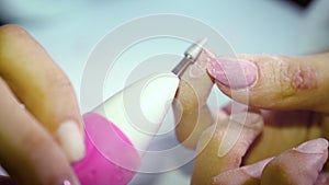 Girl at home removes nail polish with a special machine to prepare for a manicure. Close up