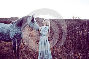 Girl in the hooded cloak with horse, effect of toning