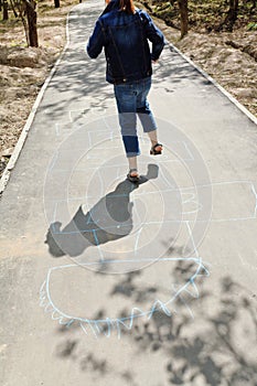 Girl hopping in hopscotch on urban alley