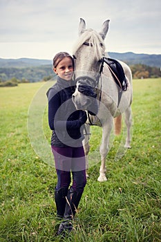 Girl with horse. Friendship between a girl and a horse. The girl is petting a horse