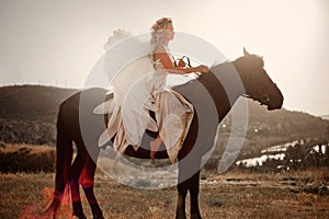 A girl on a horse with white angel wings at a horse