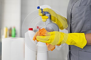 Girl hotel worker with cleaning products doing cleaning in the bathroom with a rag and a means for cleanliness