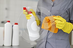 girl hotel worker with cleaning products doing cleaning in the bathroom with a rag and a means for cleanliness