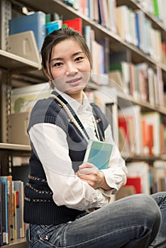 Girl huggering a book near bookshelf