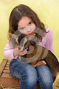 Girl hugging baby goat