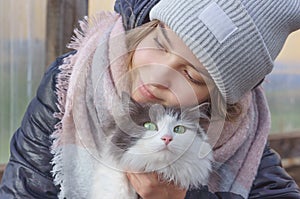 Girl hugging a cat with green eyes