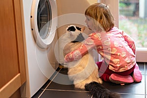 Girl hugging cat in kitchen