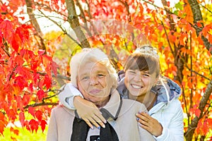 Girl hugging her old grandmother in park