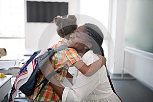 Girl hugging her pleasant teacher while feeling thankful