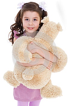 Girl hugging her teddy bear.