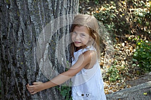 Girl hugging tree trunk