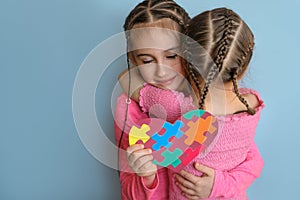 Girl hugs autistic sister tightly as sign of support and comforts.