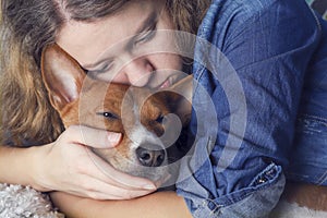 The girl hugs the basenji dog