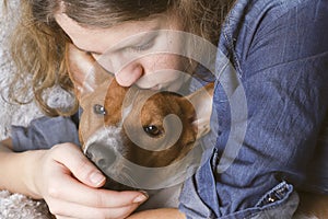 The girl hugs the basenji dog