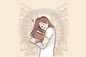 Girl hugs stack of books standing in library or bookstore and rejoicing at opportunity to read lot