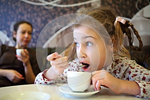 Girl hurriedly drinking tea with spoon while