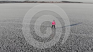 Girl ice skating roll on a frozen huge pond. View from above. Snc with a quadcopter