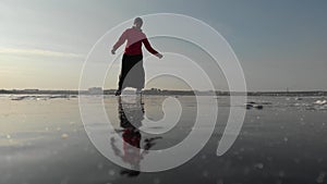 Girl ice skating roll on a frozen huge pond. View from above. Snc with a quadcopter