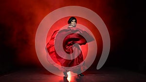 Girl in an incendiary dance of flamenco . Llight from behind. Smoke background. Slow motion