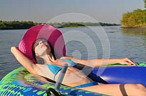 Girl on an inflatable boat in a hat