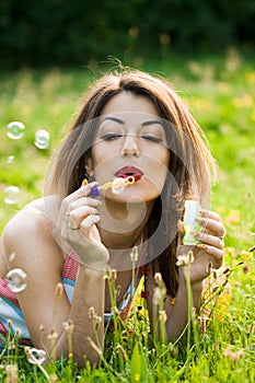 Girl inflating soap-bubbles