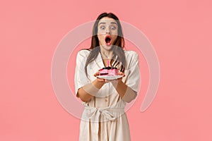 Girl inhale air, breathes deep to blow-out birthday candle and make wish come true. Attractive cheerful female in dress