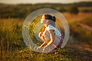 Girl inhales aroma of a wildflower