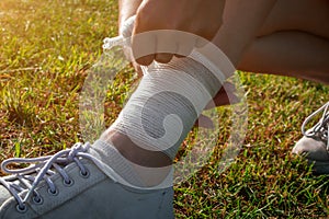 The girl injured the tendons on her leg during an outdoor jogging. Self-bandaging. Running leg injury accident woman runners.