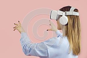Girl in innovative headset playing video game, experiencing VR, touching virtual objects