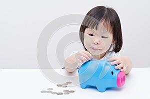 Girl insert coin into piggy bank